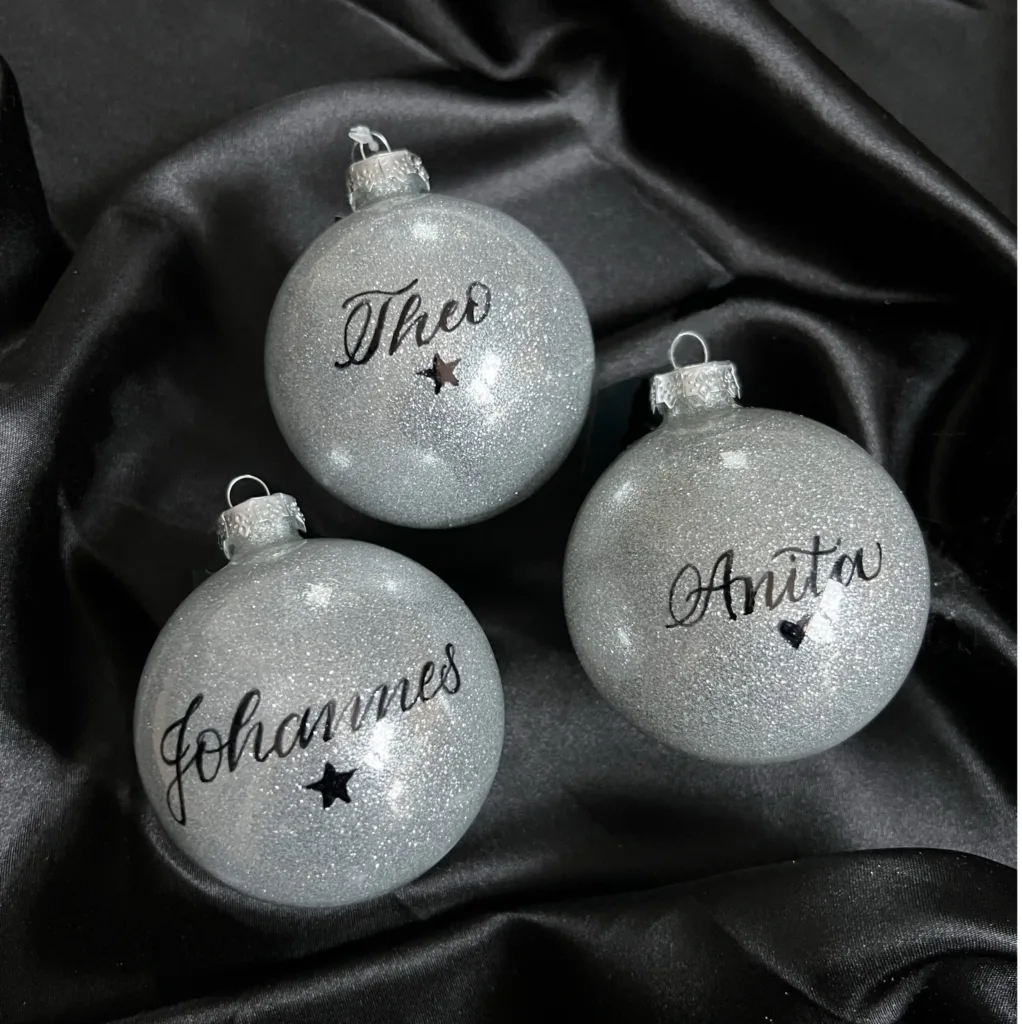 Silberne Christbaumkugeln mit handgeschriebenen Namen