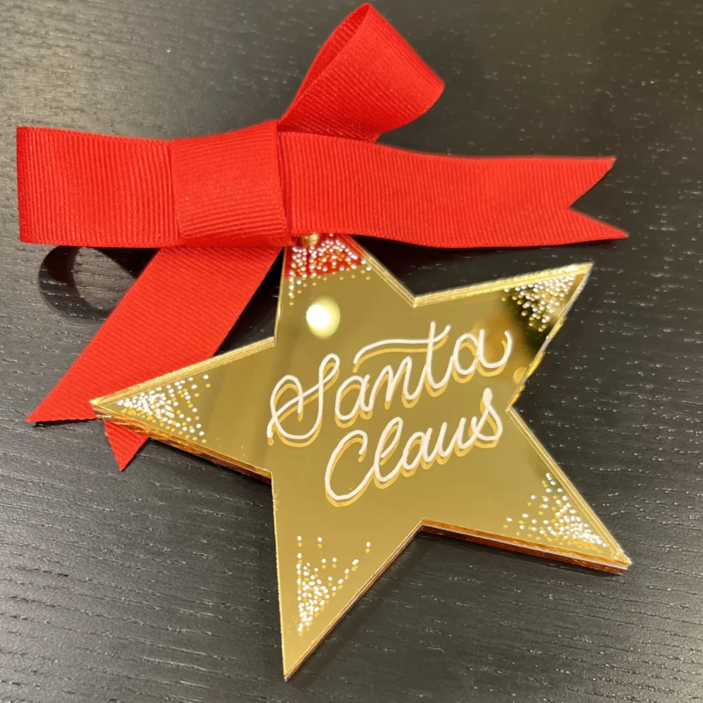 Christbaumanhänger in Sternform mit Santa Claus und roter Schleife