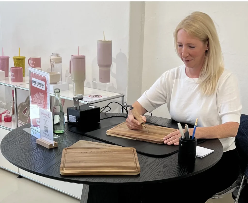 Brandmalerei mit einem Brandmalkolben auf Holz während eines Influencer Events